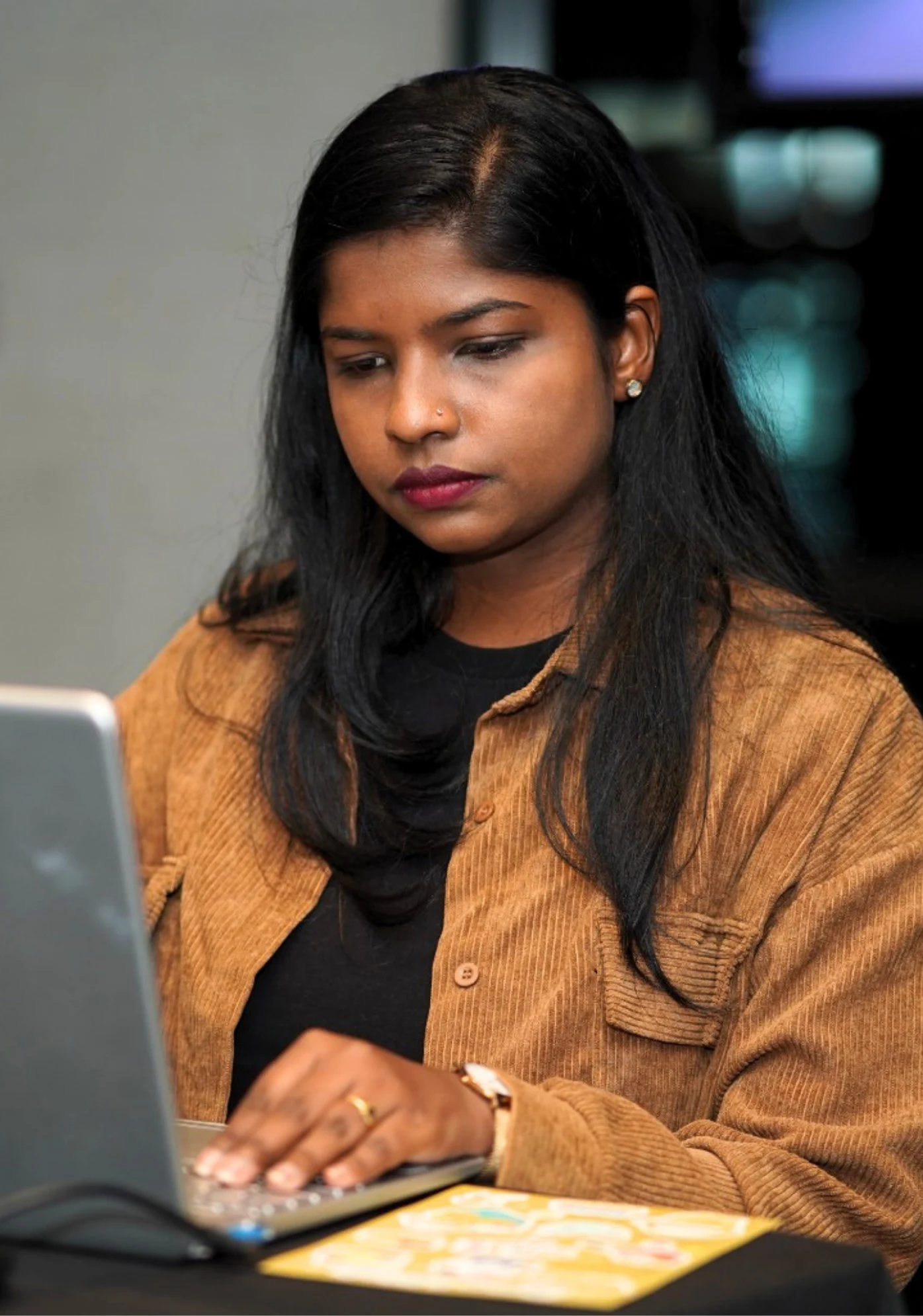 Pauline Suzanna working on a laptop while developing professional projects and leadership initiatives.